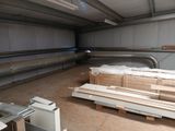 plusieurs pièces de bois sont empilées sur des palettes dans un local de stockage