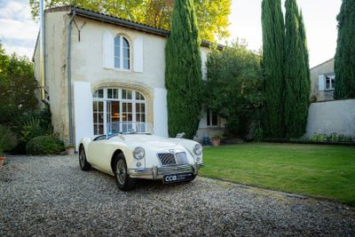 une photo d'une voiture de collection garée devant une maison