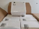 boxes of white paper are stacked on top of each other in a room