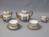 a tea set with a cup and saucer on the table