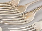 a lot of forks and spoons that are on the table