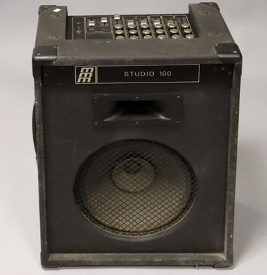 an old amp with a speaker on top of it on a white surface