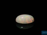 a white oplite stone on a black surface