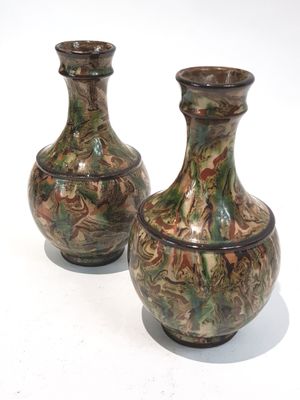deux vases posés sur une surface blanche