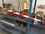 a red and white striped tape on a shelf in a warehouse