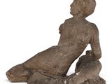 an image of a statue of a woman sitting on a rock