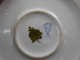 a white plate with a flower on it and a blue rose on it