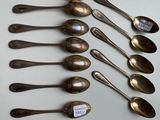 six silver spoons are lined up in a row on a table