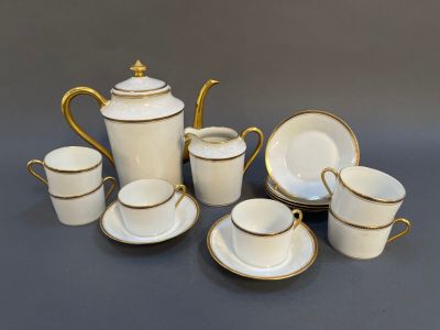an image of a white and gold tea set with cups and saucers