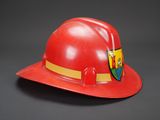 red fireman ' s hat with a crest on the side