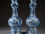 une paire de vases bleus et blancs ornés de personnages
