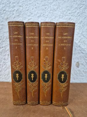 four old books sitting on top of a table next to each other