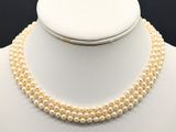 a close up of a necklace with pearls on a mannequin