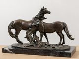 statue of two horses on a marble base on a wooden table