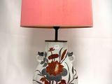 a lamp that is sitting on a table with a pink shade on it