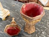 a small red vase and a small white vase on a table