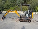 une petite excavatrice garée sur un parking