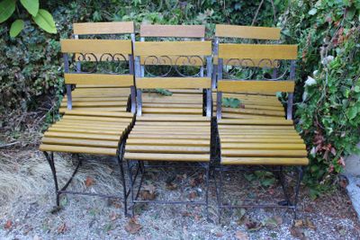 trois bancs en bois placés les uns à côté des autres dans l'herbe