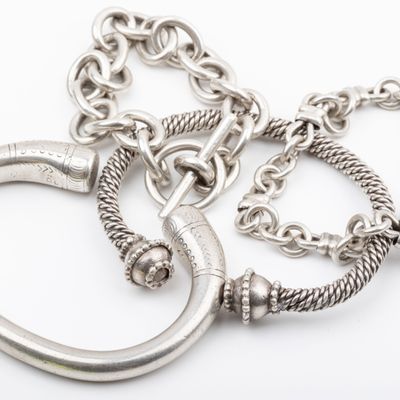 two silver metal rings and a chain on a white background