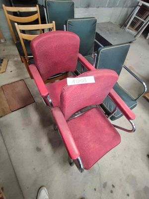 une chaise rouge qui se trouve au milieu d'une pièce