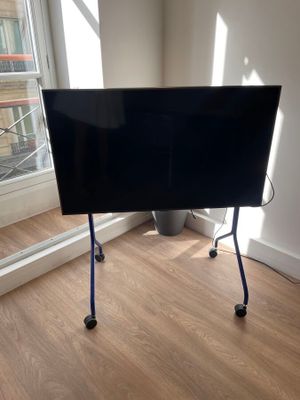 un téléviseur à écran plat sur un support dans le coin d'une pièce