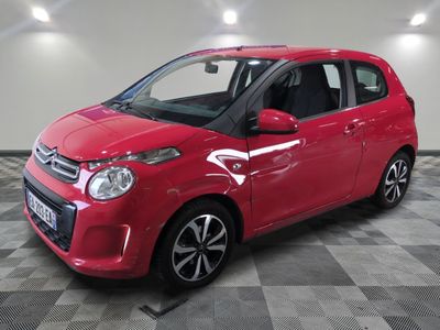 la petite voiture rouge est garée sur un sol en damier