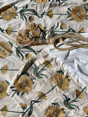 an image of a bed with a white and yellow floral comforter