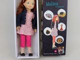une poupée Barbie dans une boîte, accompagnée d'instructions pour lui donner l'apparence d'une poupée
