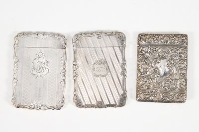 trois étuis à cigarettes en argent posés les uns à côté des autres sur une surface blanche