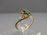 une image représentant une bague en or ornée de deux pierres vertes