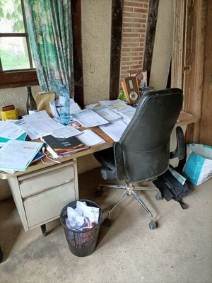 un bureau avec une chaise et quelques papiers dessus