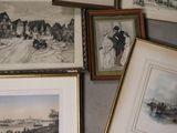 many framed pictures on the wall of a room