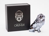 the silver lion figurine is next to a black box