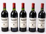 quatre bouteilles de vin sont alignées sur une surface blanche