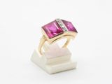un gros plan d'une bague sertie d'un diamant rose et blanc posée sur un bloc de marbre