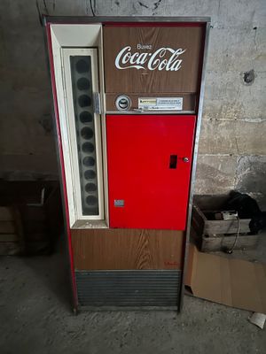 un distributeur de Coca-Cola qui se trouve dans une pièce