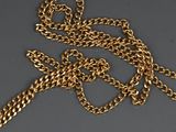 a close up of a gold chain with a cross on it