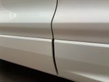 a close up of a white car with a broken door handle