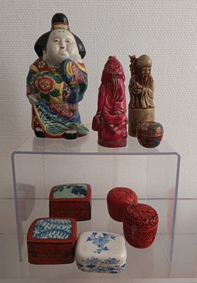 a glass display case with a variety of asian figurines on it