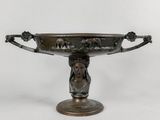an antique bronze bowl with a woman ' s head on it