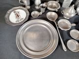 a lot of silver dishes and cups on the table