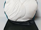 a white and blue pillow sitting on top of a black mat