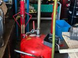 un réservoir d'essence rouge posé à côté d'une borne d'incendie rouge dans un garage