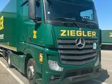 a green truck that is parked in a parking lot
