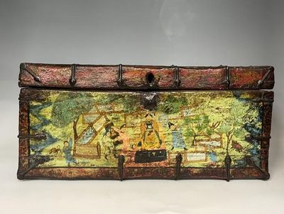 une vieille malle décorée d'une peinture, posée sur une table