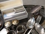 a tray of silverware on a table with silver spoons and forks