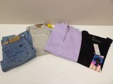 Trois paires de jeans et un t-shirt sont posés sur une table
