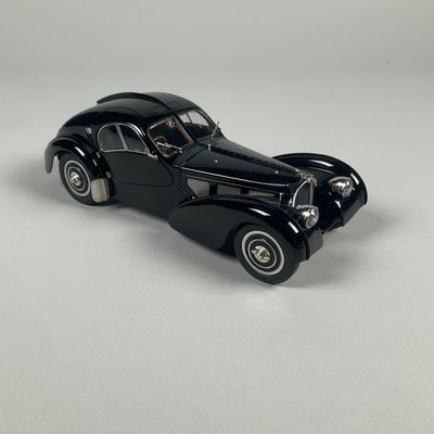 a black toy car sitting on top of a white surface