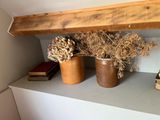 two vases with flowers on a shelf in a room