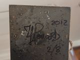 someone is holding a piece of metal with writing on it
